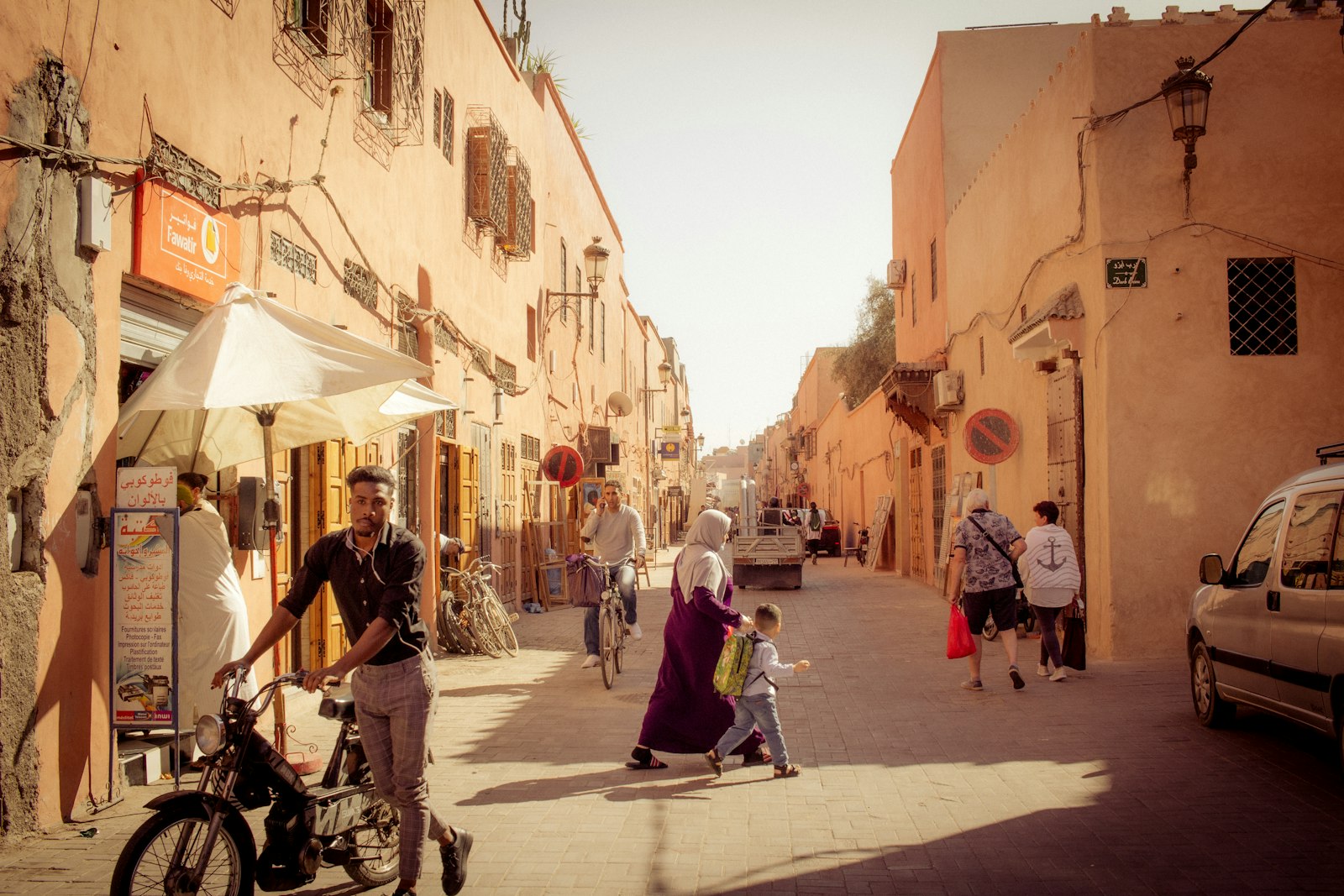 عن ال جي صيانة: من نحن وما لا نعمل فيه — أشخاص يسيرون في شارع ضيق بين مبانٍ سكنية عالية وقت العصر أشخاص يسيرون في شارع ضيق بين مبانٍ سكنية عالية وقت العصر